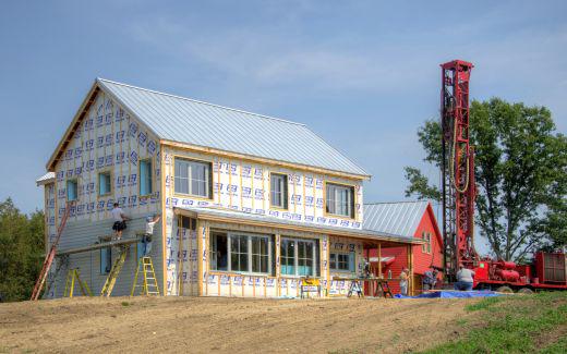 Installing siding and drilling for water