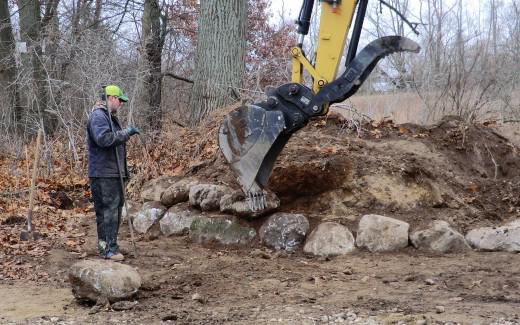 Bruce from Bostwick Excavating guiding stone placement